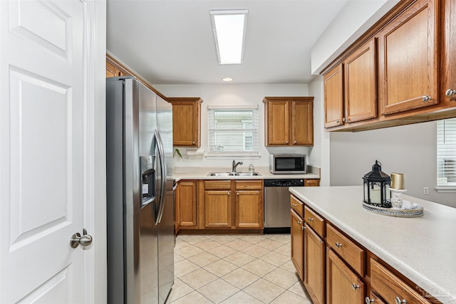 5397 Fawn Ridge Dr, Gulf Breeze, FL 32563 - kitchen featuring appliances with stainless steel finishes, brown cabinetry, light tile patterned flooring, and light countertops