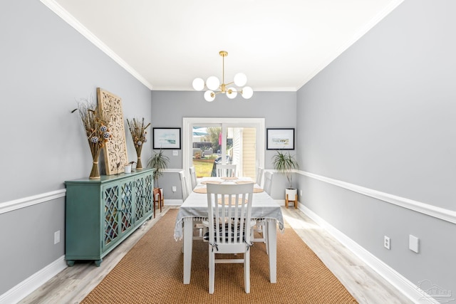 dining area with baseboards, light wood-style flooring, a chandelier, and crown molding