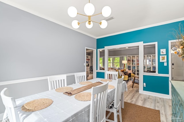 dining area featuring visible vents, wood finished floors, a chandelier, and crown molding