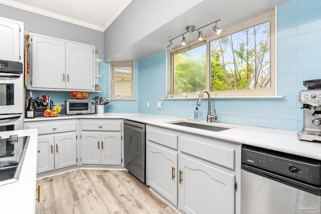 kitchen featuring a sink, crown molding, dishwasher, and white cabinets