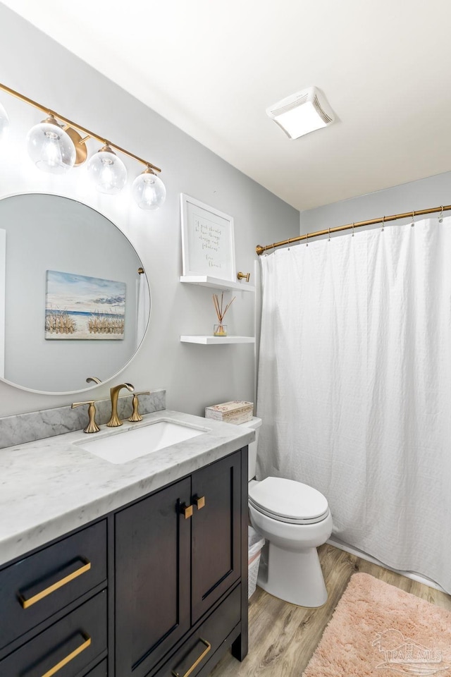 bathroom with toilet, vanity, a shower with shower curtain, and wood finished floors