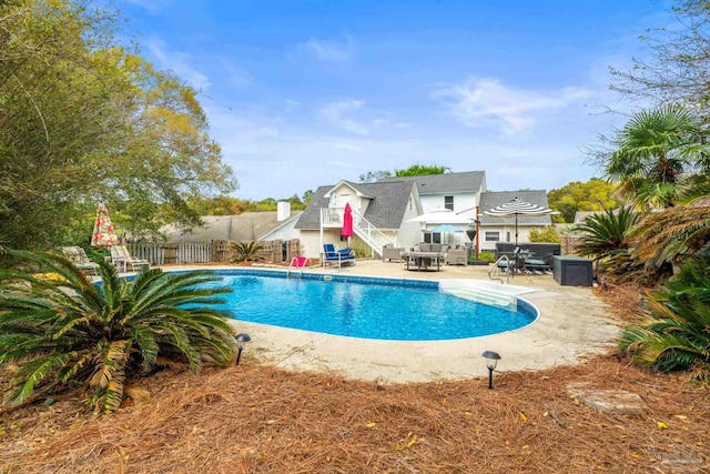 outdoor pool featuring fence and a patio
