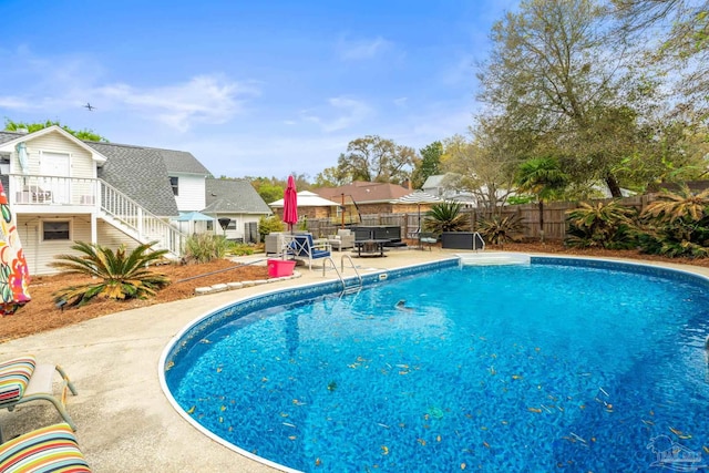 view of swimming pool featuring a fenced in pool, a fenced backyard, stairway, and a patio area