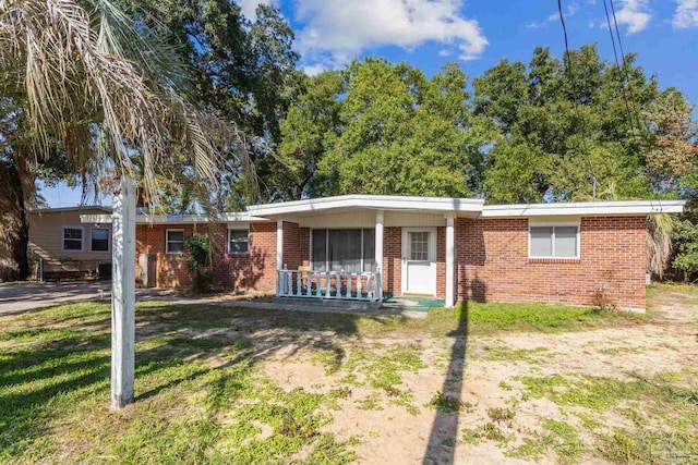 ranch-style home with a porch and a front lawn