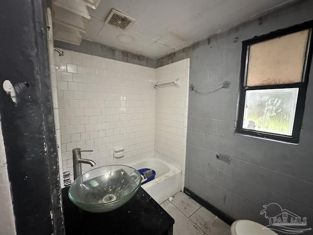 bathroom featuring tiled shower / bath and sink