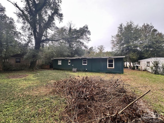 back of house with a yard and central AC