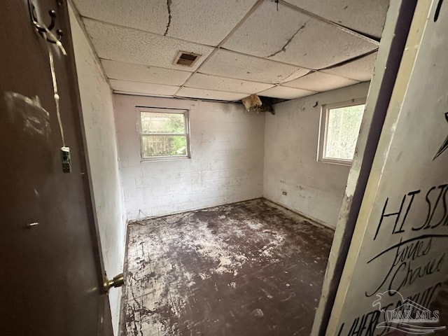 basement with plenty of natural light and a drop ceiling