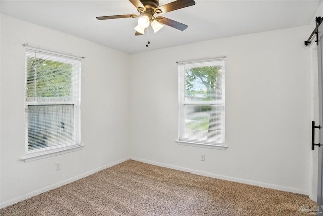 4248 Seaport Rd, Pace, FL 32571 - spare room featuring a barn door, carpet floors, ceiling fan, and baseboards