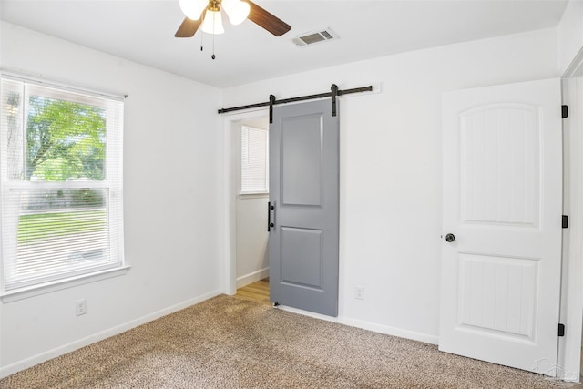 4248 Seaport Rd, Pace, FL 32571 - unfurnished bedroom featuring light colored carpet, a barn door, baseboards, and ceiling fan