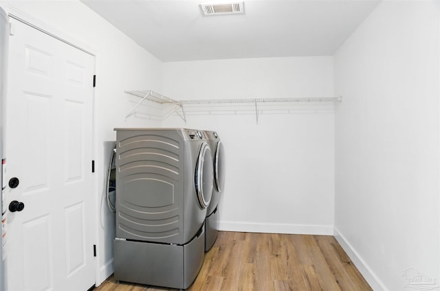 4248 Seaport Rd, Pace, FL 32571 - washroom featuring separate washer and dryer, light wood-style floors, and baseboards