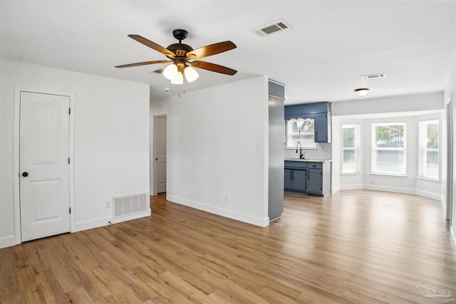 4248 Seaport Rd, Pace, FL 32571 - unfurnished living room with light wood-style floors, baseboards, ceiling fan, and a sink