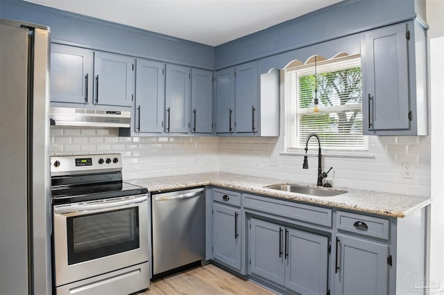 4248 Seaport Rd, Pace, FL 32571 - kitchen featuring stainless steel appliances, under cabinet range hood, a sink, backsplash, and light stone countertops