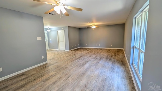 empty room with hardwood / wood-style floors and ceiling fan