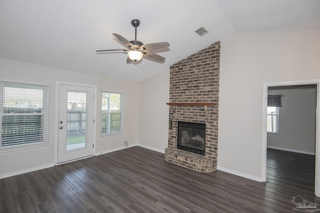 unfurnished living room with lofted ceiling, a fireplace, dark wood-style flooring, and a wealth of natural light