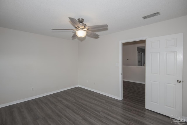 unfurnished room with baseboards, visible vents, a ceiling fan, dark wood finished floors, and a textured ceiling