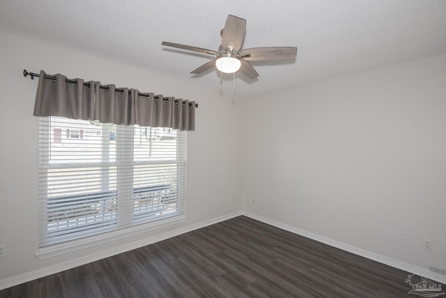 empty room with ceiling fan, a textured ceiling, baseboards, and dark wood-style flooring