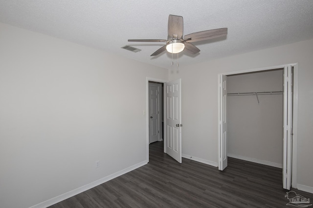 unfurnished bedroom featuring dark wood-style floors, a textured ceiling, baseboards, and a closet