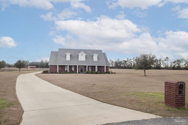 cape cod house with a front yard