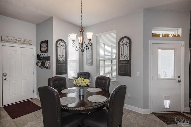 dining space with light tile patterned floors and an inviting chandelier