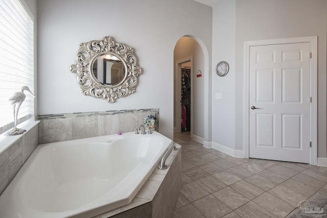 bathroom with a relaxing tiled tub