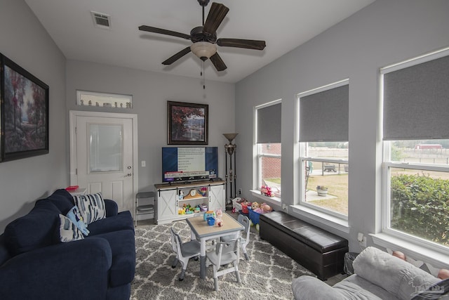 living room featuring a healthy amount of sunlight and ceiling fan