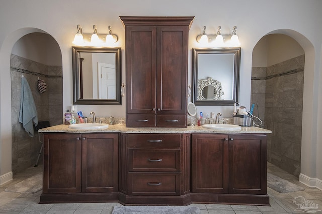 bathroom with vanity and tiled shower