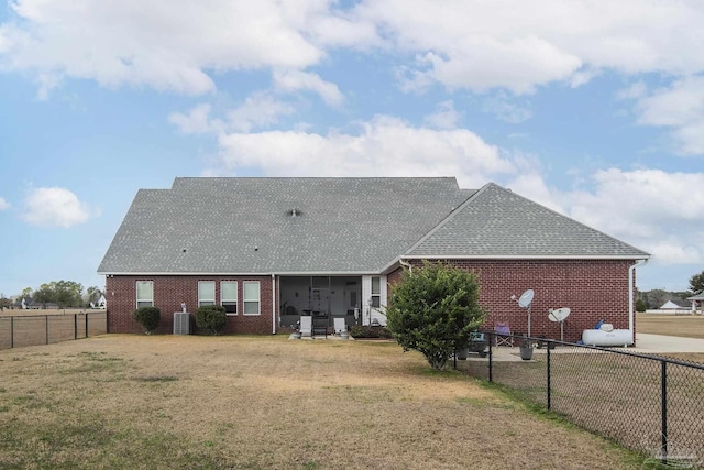 back of house with a sunroom and a lawn