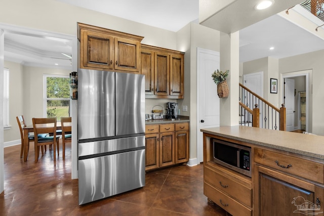 kitchen with ornamental molding and appliances with stainless steel finishes