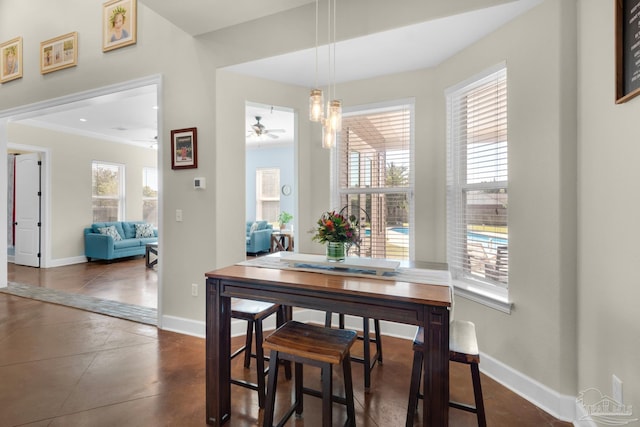 dining space featuring dark tile patterned floors, crown molding, and ceiling fan