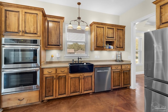 kitchen featuring appliances with stainless steel finishes, decorative light fixtures, sink, and a wealth of natural light