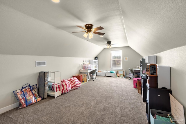 recreation room featuring lofted ceiling, a textured ceiling, carpet flooring, and ceiling fan