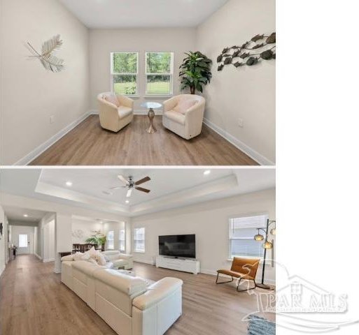 living room with light wood-type flooring, a tray ceiling, and ceiling fan