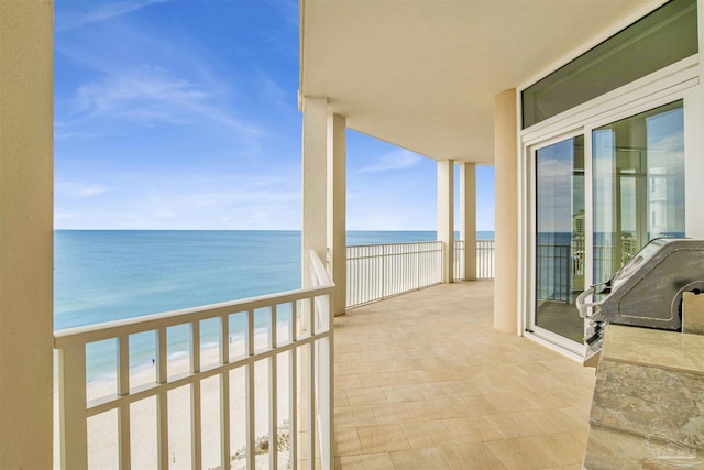 balcony with a water view and a beach view