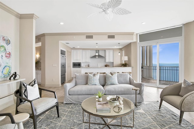 tiled living room with a water view, ceiling fan, and ornamental molding