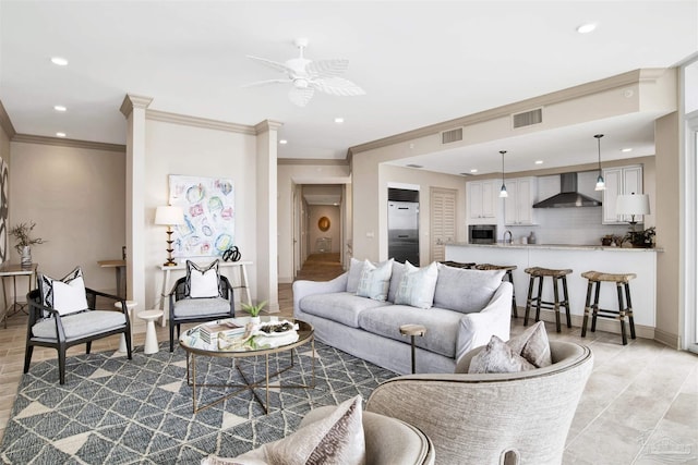 living room with crown molding, ceiling fan, and sink