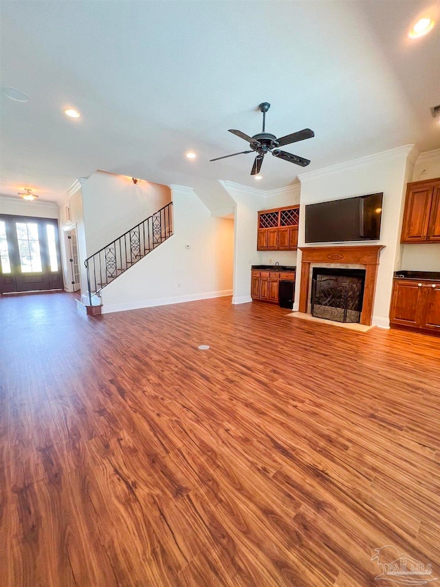 unfurnished living room with ornamental molding, ceiling fan, and hardwood / wood-style floors