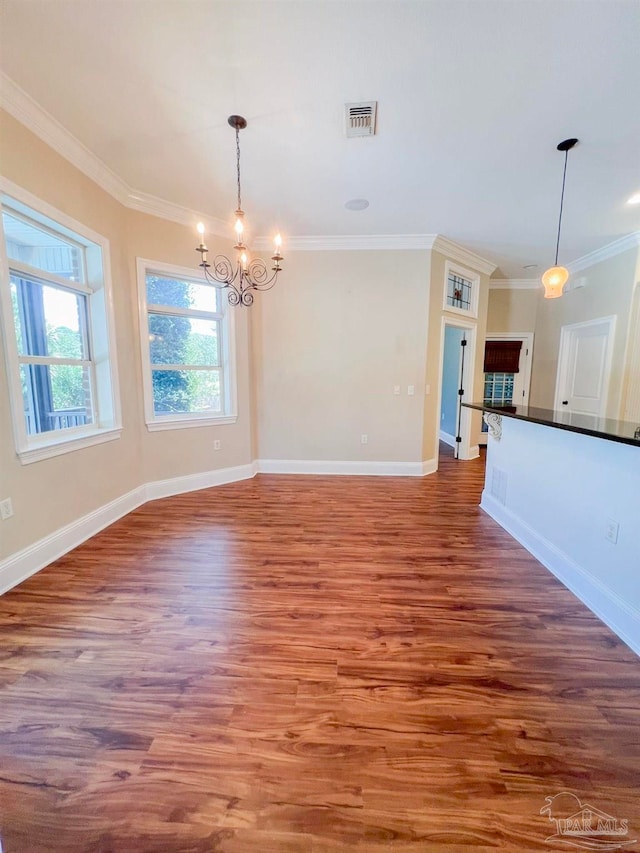 unfurnished living room featuring light hardwood / wood-style floors, ornamental molding, and an inviting chandelier