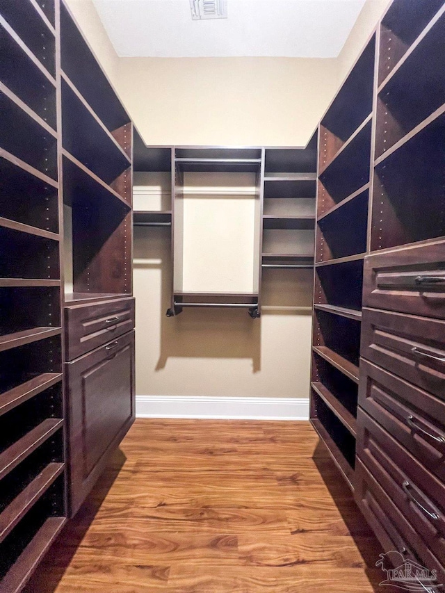 spacious closet with hardwood / wood-style floors