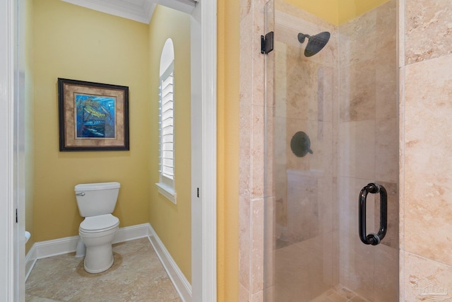 bathroom with a shower with door, crown molding, and toilet