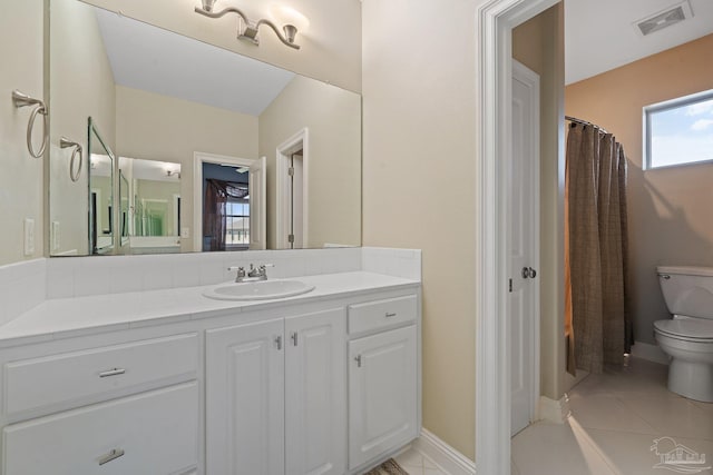 bathroom featuring plenty of natural light, vanity, tile patterned flooring, and toilet