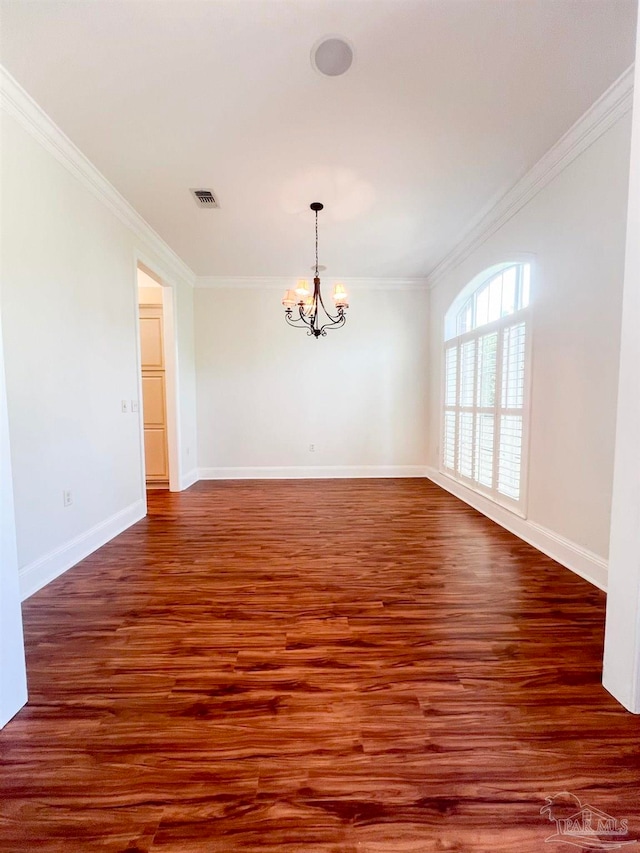 spare room featuring an inviting chandelier, hardwood / wood-style flooring, and ornamental molding