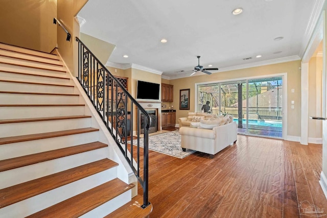 unfurnished living room with ornamental molding, hardwood / wood-style floors, and ceiling fan