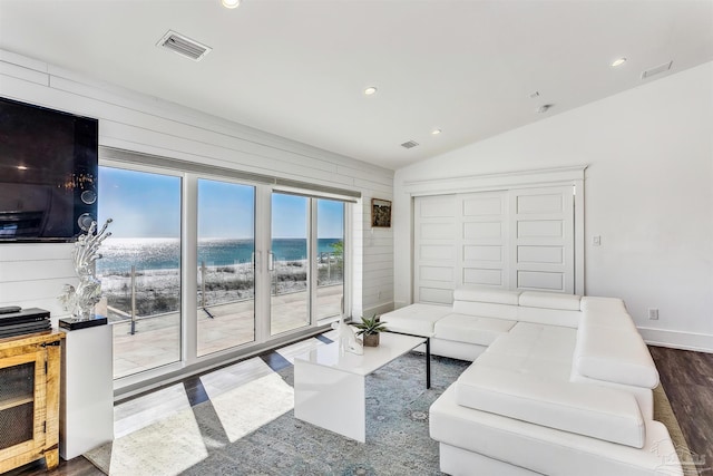 living room with vaulted ceiling, a water view, and hardwood / wood-style floors