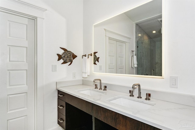 bathroom with tiled shower and double sink vanity