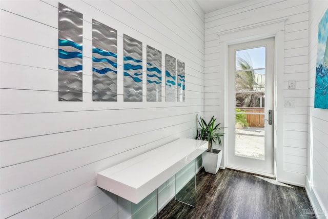 mudroom featuring dark wood-type flooring and wooden walls