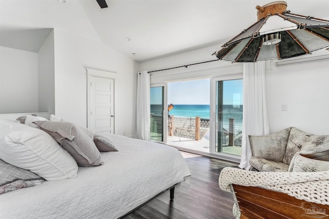 bedroom with multiple windows, wood-type flooring, access to outside, and a water view