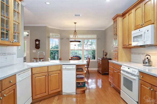 kitchen with crown molding, sink, white appliances, and hanging light fixtures