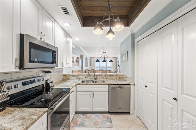 kitchen featuring stainless steel appliances, white cabinetry, and decorative light fixtures