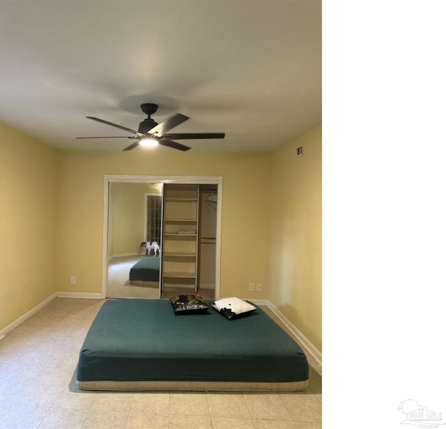 unfurnished bedroom with ceiling fan and a closet