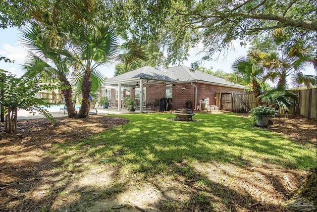 1707 Cedrus Ln, Pensacola, FL 32514 - back of house with a fenced backyard, a patio area, an outdoor fire pit, and brick siding